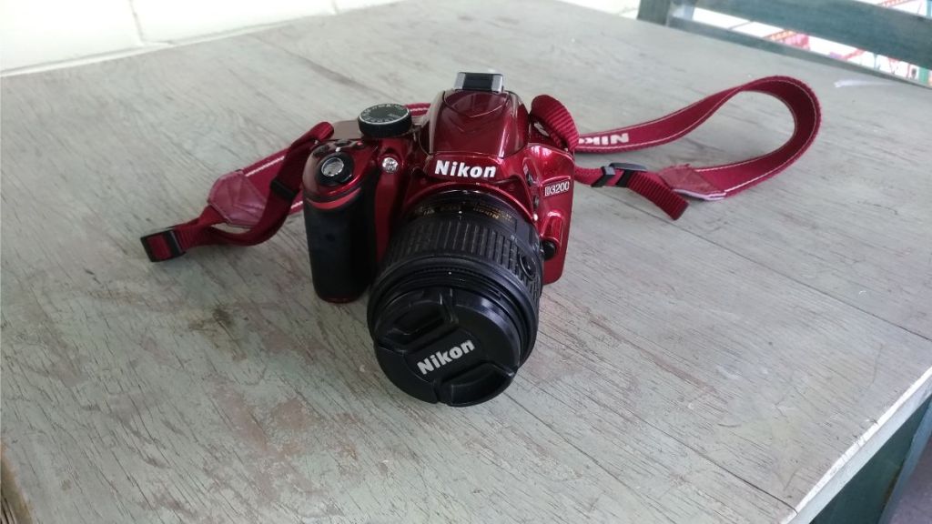 Red Nikon Camera resting on a table