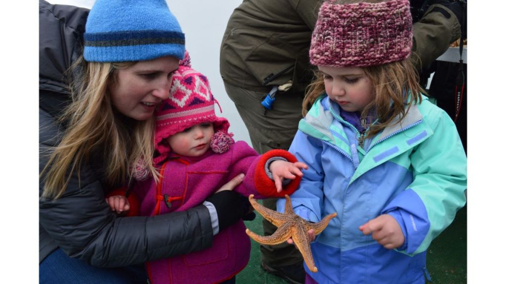 Two young girls holding a fresh starfish