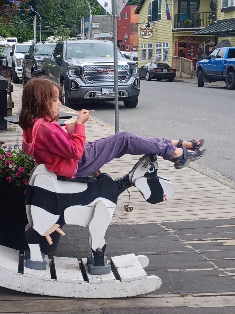 Child eating ice cream on rocking horse painted like a cow
