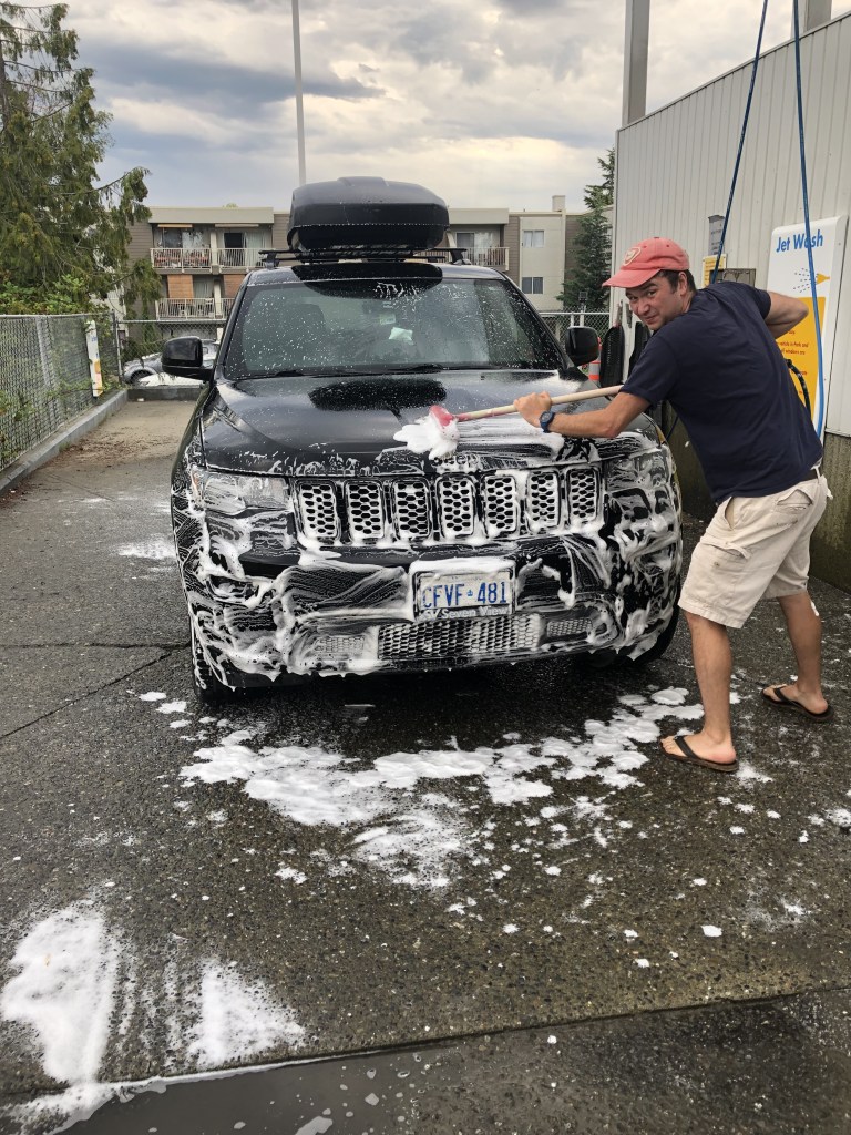 Man washing car with soap brush