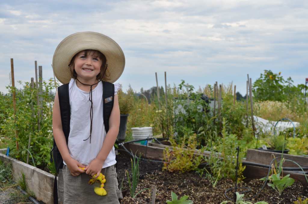 Child with flower at organic farm Sidney
