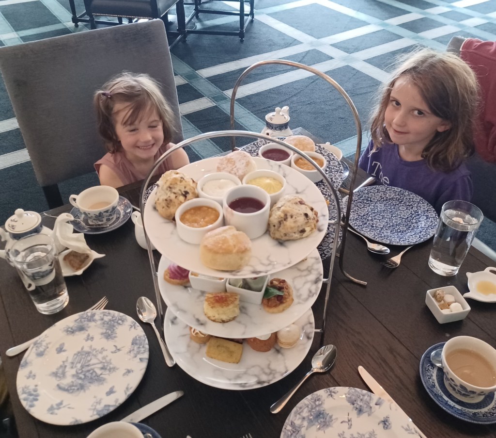 Two girls smiling with food on platter