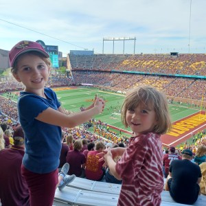 Two kids smiling at a college football game