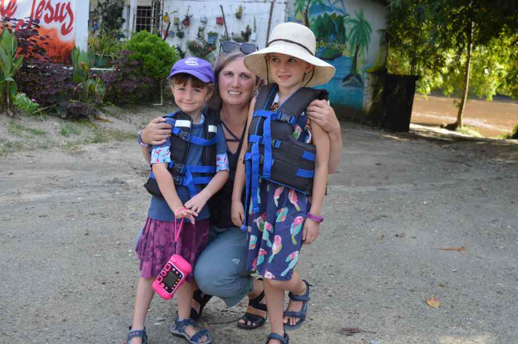 Children with mother in lifejackets beside river