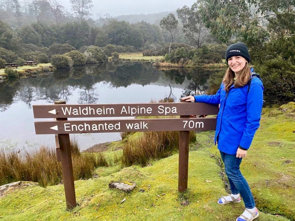 Lady standing by sign at Cradle Mountain Trail
