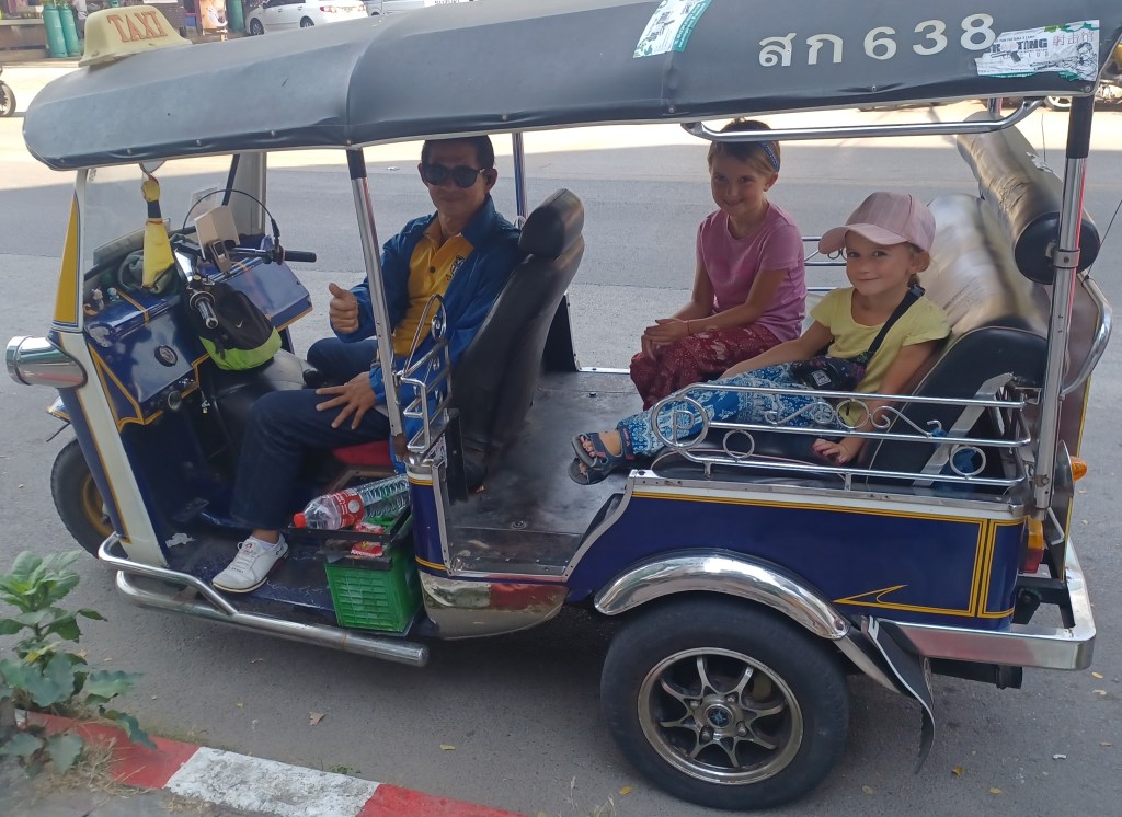 Family with Tuk Tuk driver smiling