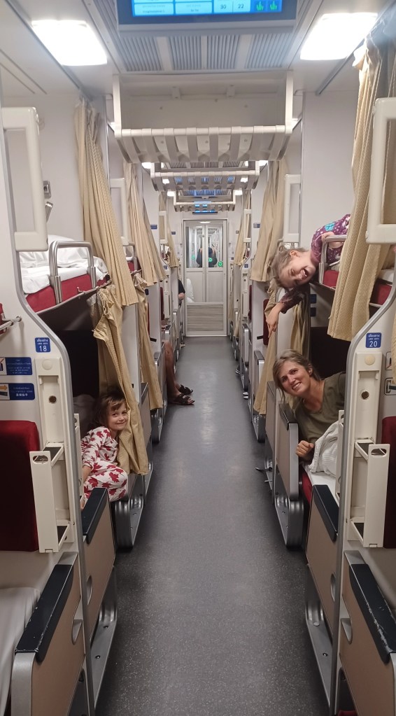 Family lying on beds on a train car