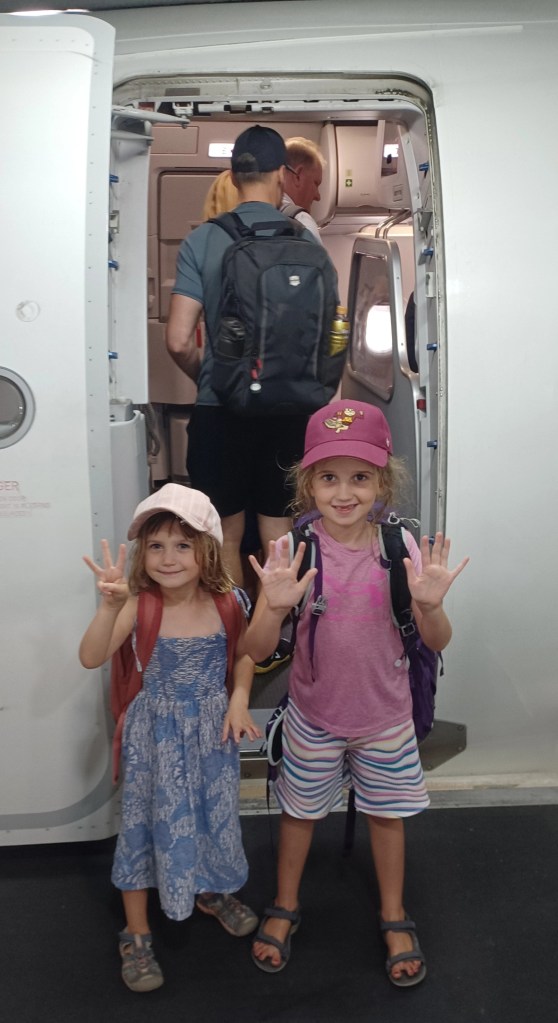 Children waving while boarding plane