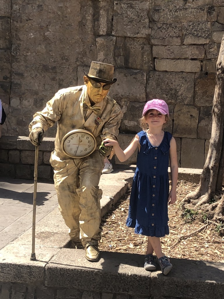 Young girl and statue street performer posing for picture