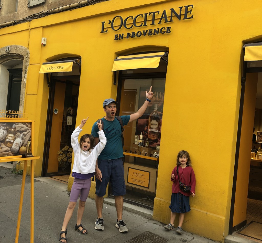 Family standing excitedly outside L'occitane store in provence