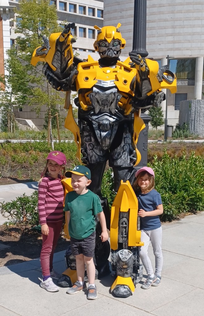 Three children with man in bumblee transformer costume