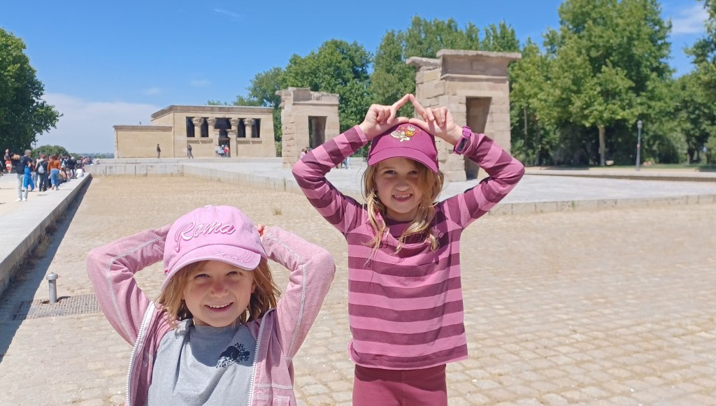 Two children smiling in front of egyptian temple in Madrid