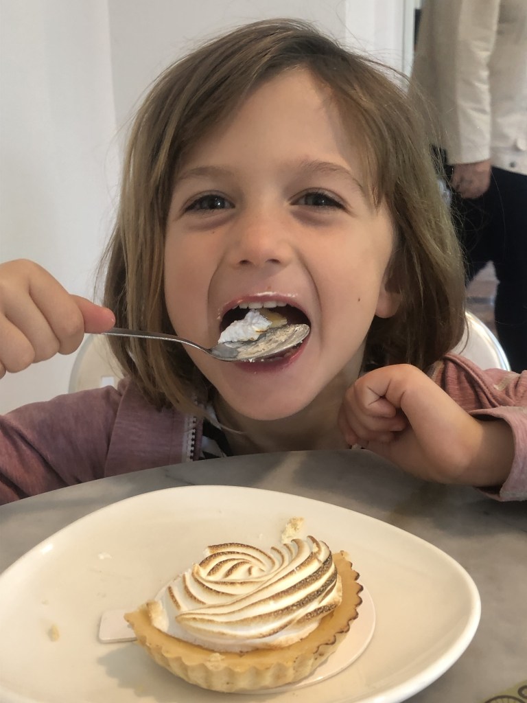 Young girl eating a fancy meringue dessert