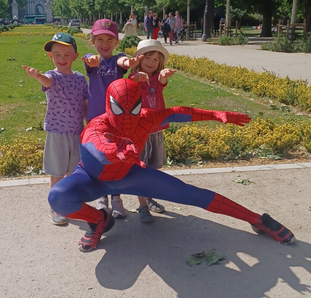 Children posing with spiderman