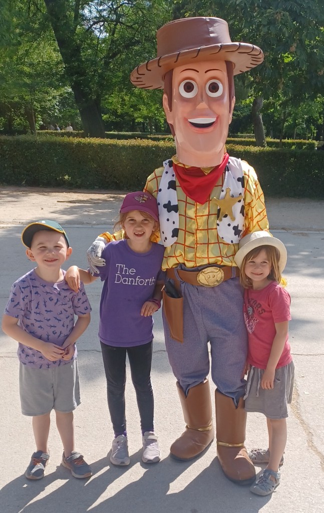 Children standing with adult entertainer in Woody from Toy Story costume