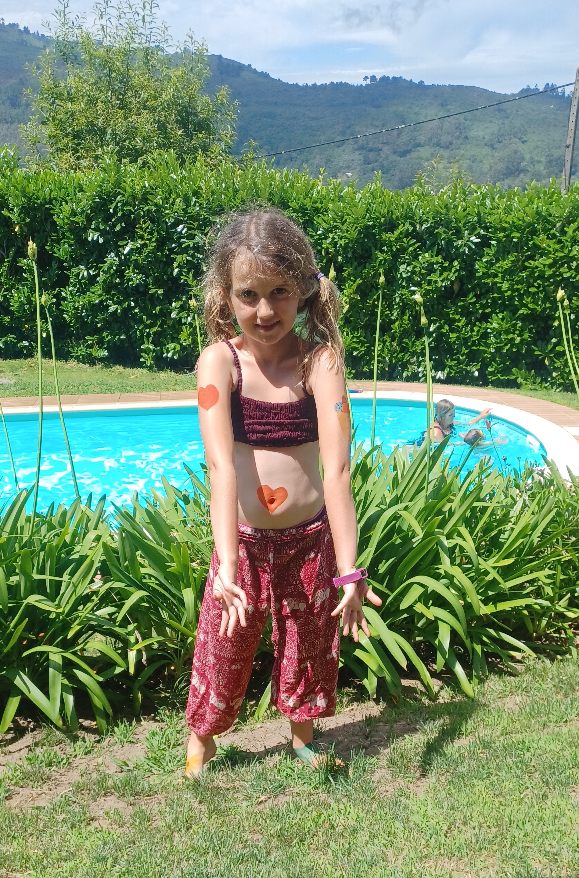 Child with body paint beside swimming pool