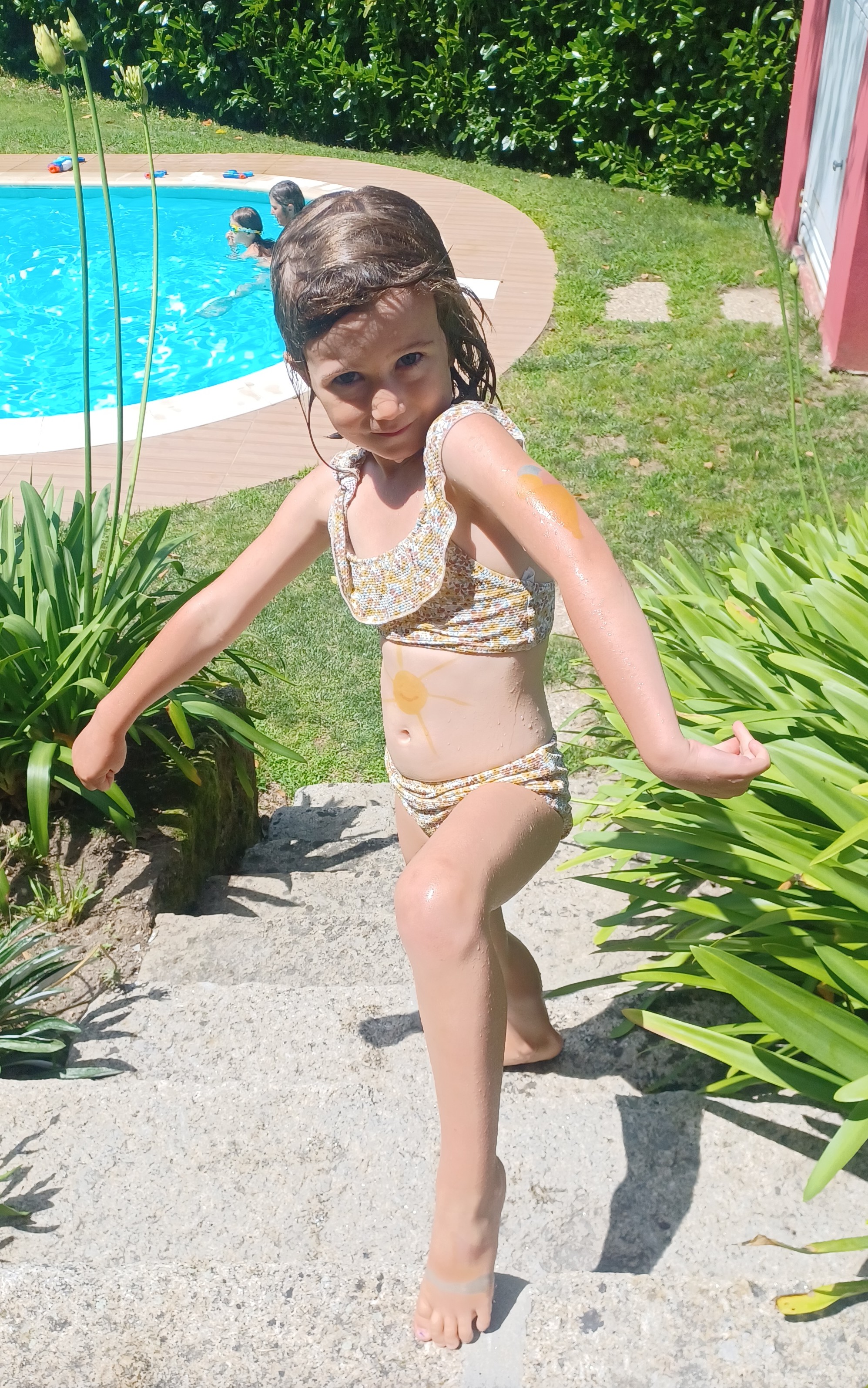 Child funny pose by pool with body paint