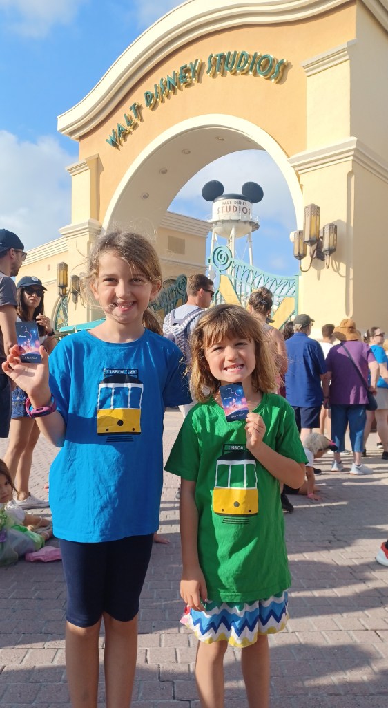 Two children with disney passes at park entrance