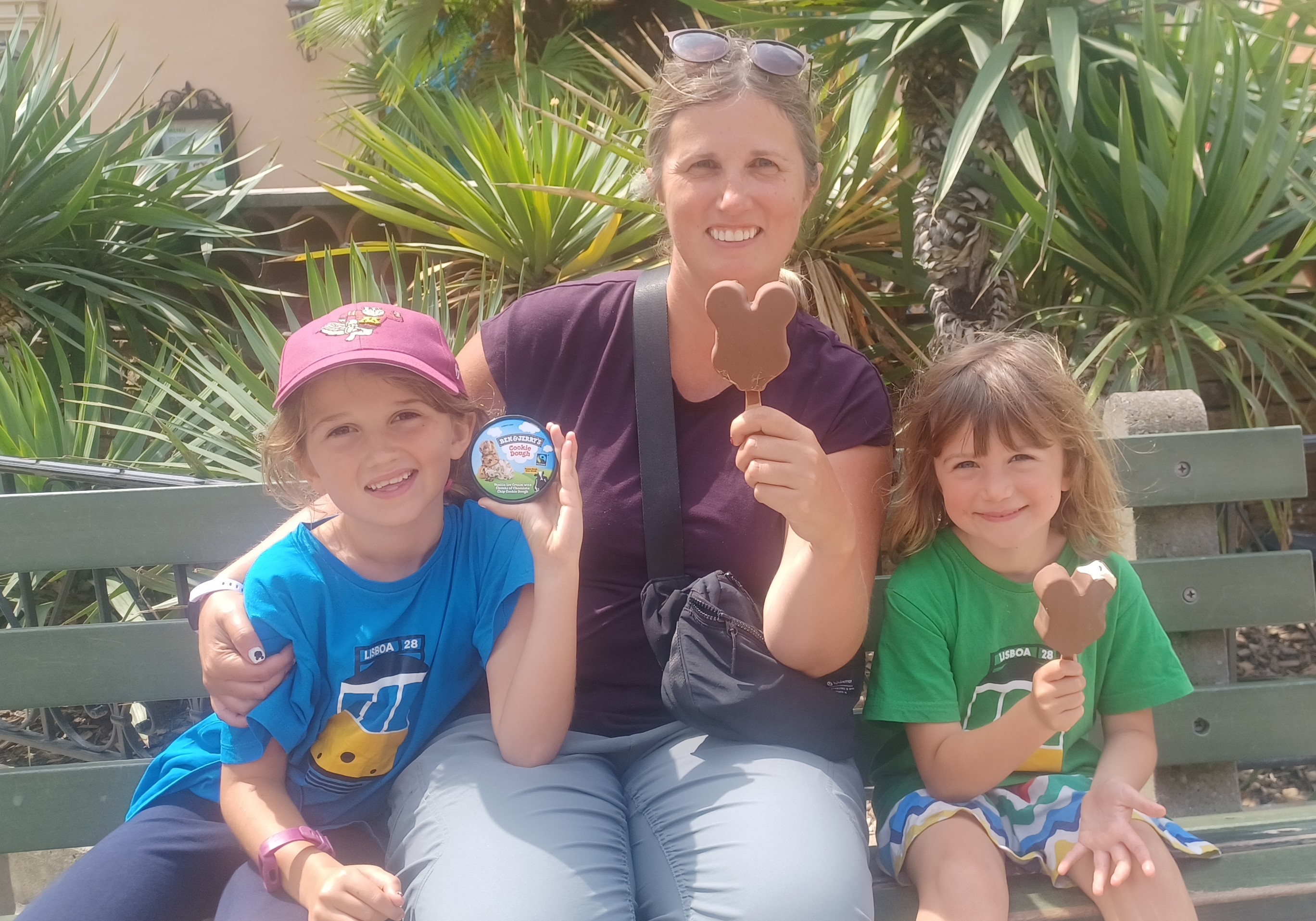 Mother and daughters eating ice cream on bench