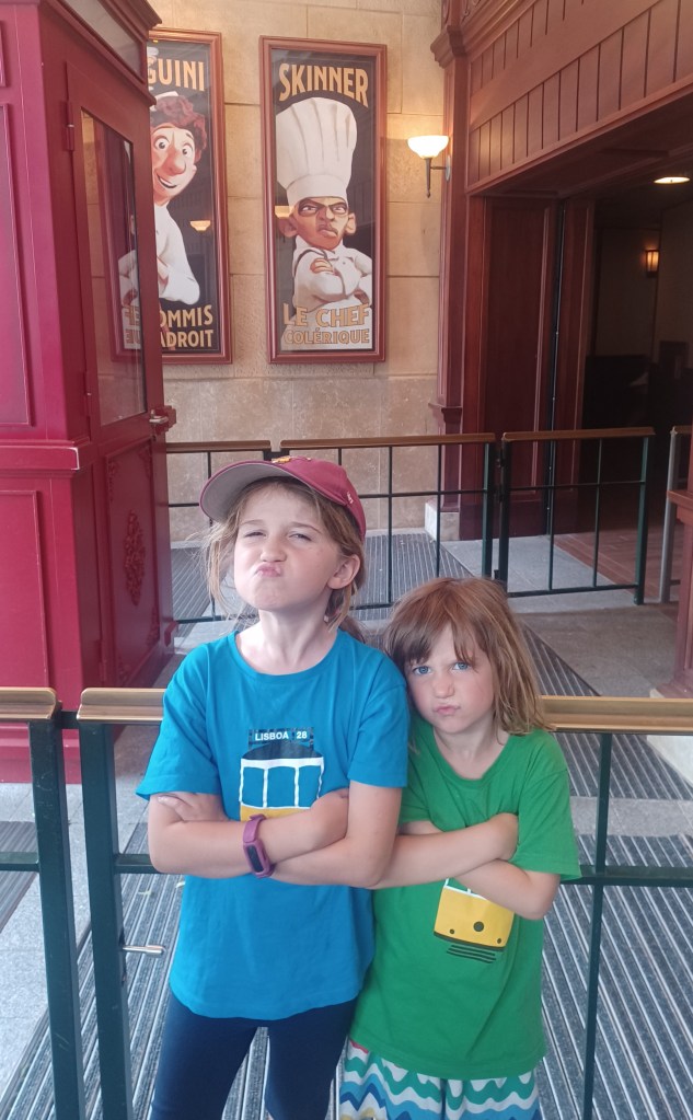Two kids making faces in queue for Ratatouille ride