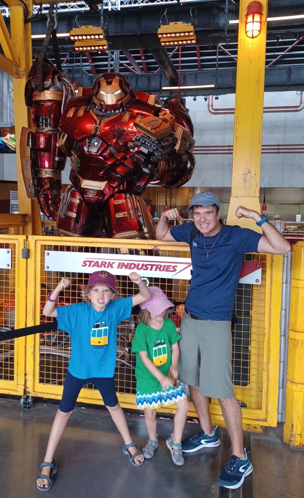 Family posing in front of hulk buster iron man